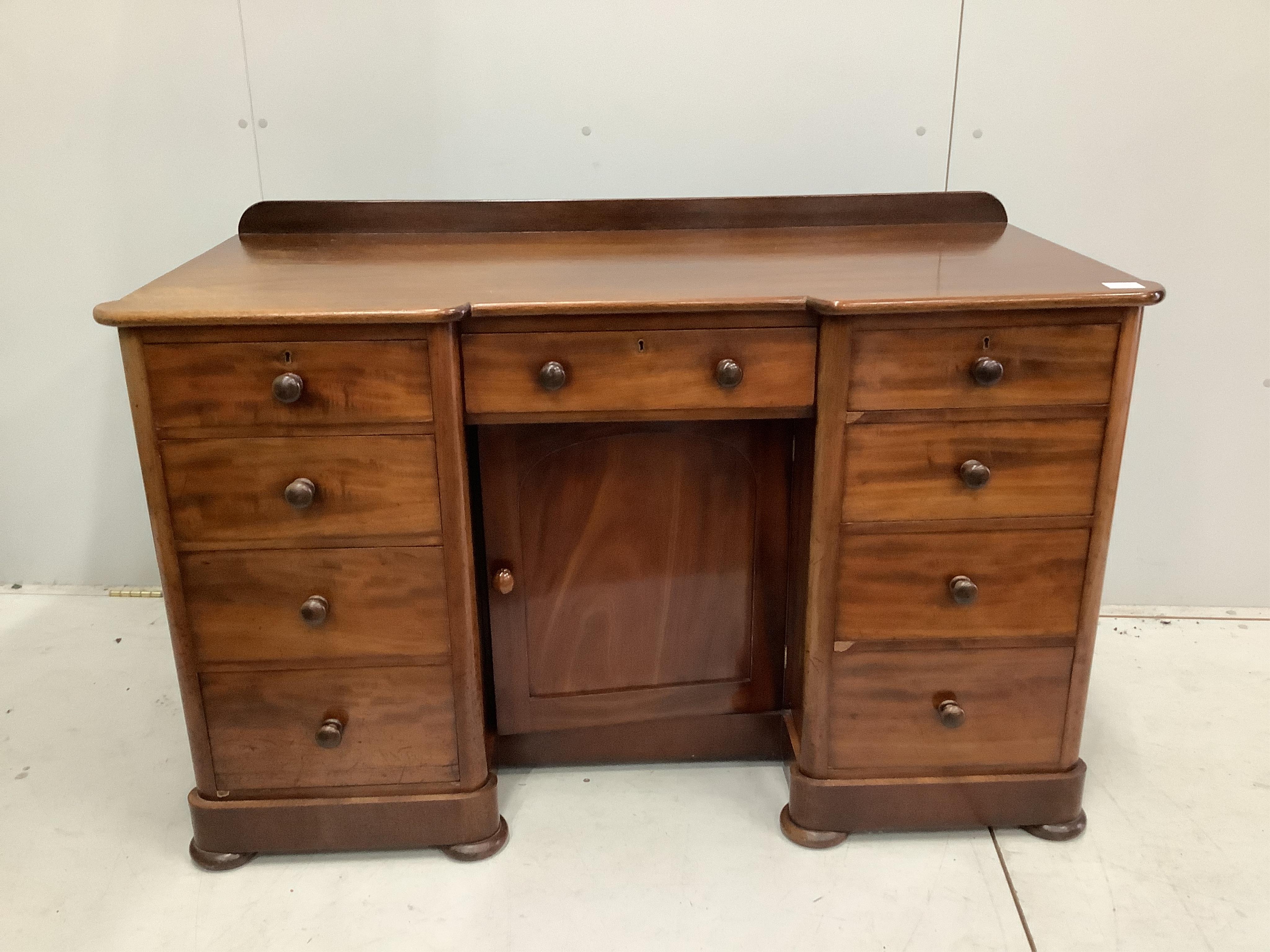 A Victorian mahogany kneehole desk, fitted nine small drawers, width 125cm, height 78cm. Condition - faded to one side, otherwise good